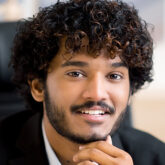 Close-up business portrait. Friendly smiling curly-haired Indian business man, small business owner, company leader or sales manager, in formal suit, successful real estate agent, looking at camera